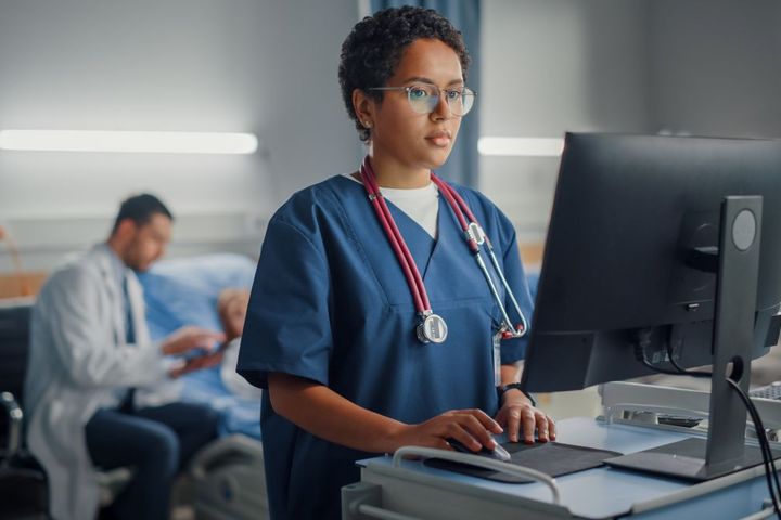 A nurse checks information recorded to the EHR by the facility's ambient AI system.