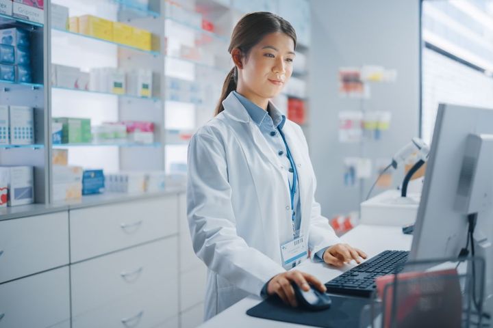 A hospital pharmacist checks the computer.