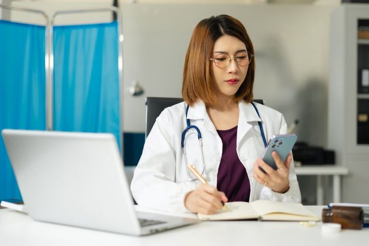 A physician checks her EHR system.