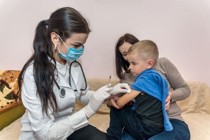 A family nurse practitioner gives a child a vaccination.