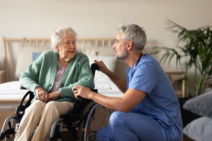 A home care nurses assists one of his patients at her home.
