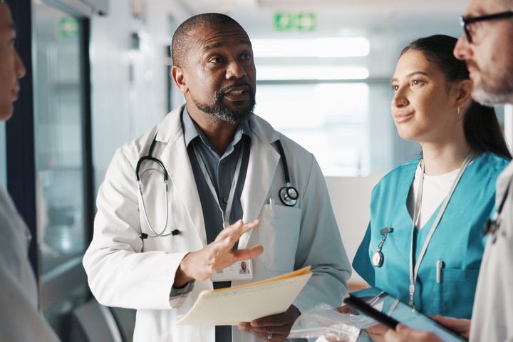 A member of hospital management meets with colleagues.