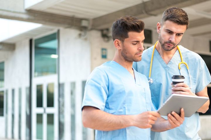 Two nurses consulting an hourly nursing shift planner.