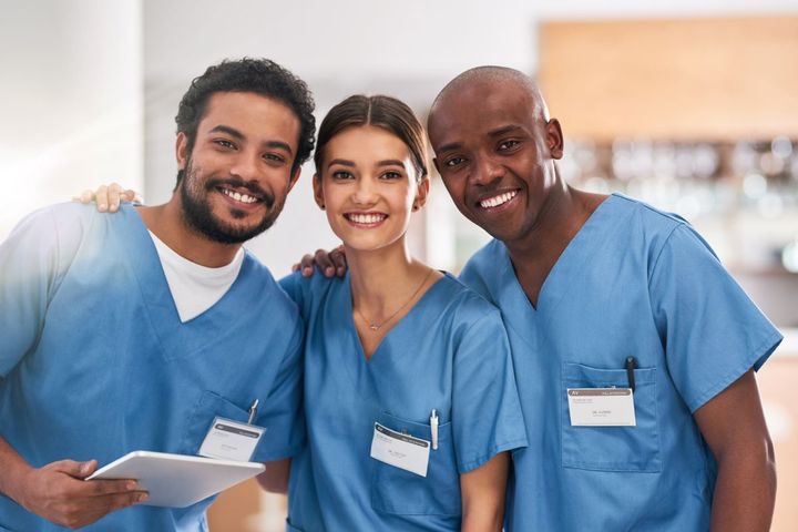 Three nurses, smiling at the camera.