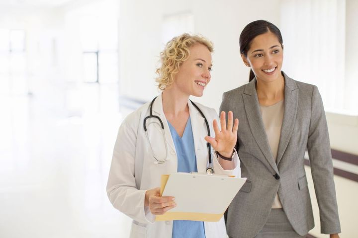 Two professional women walking through a medical office