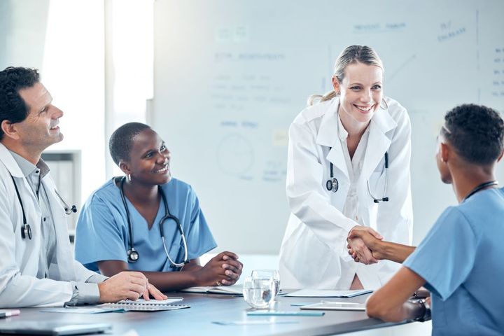 After asking a long string of RN interview questions, a nurse manager shakes the hand of her new hire.