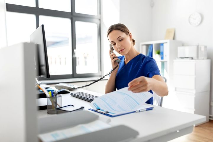 A utilization review nurse discusses suggestions while on the phone.