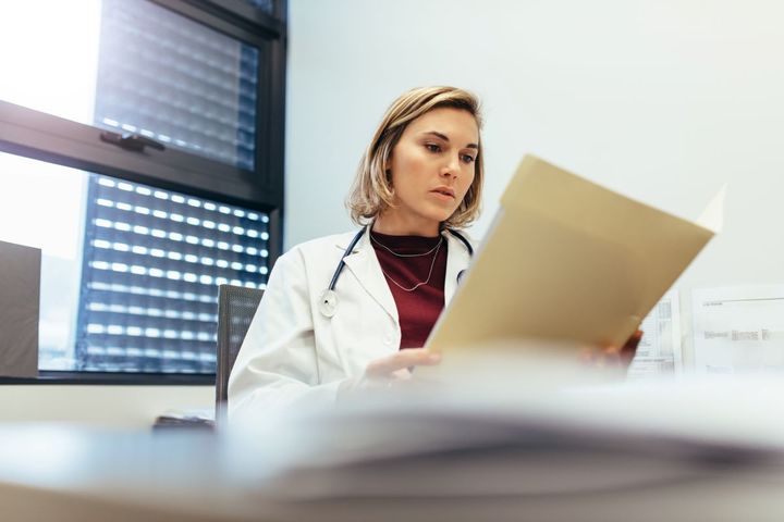 A nurse looking at medical records and CPT codes.