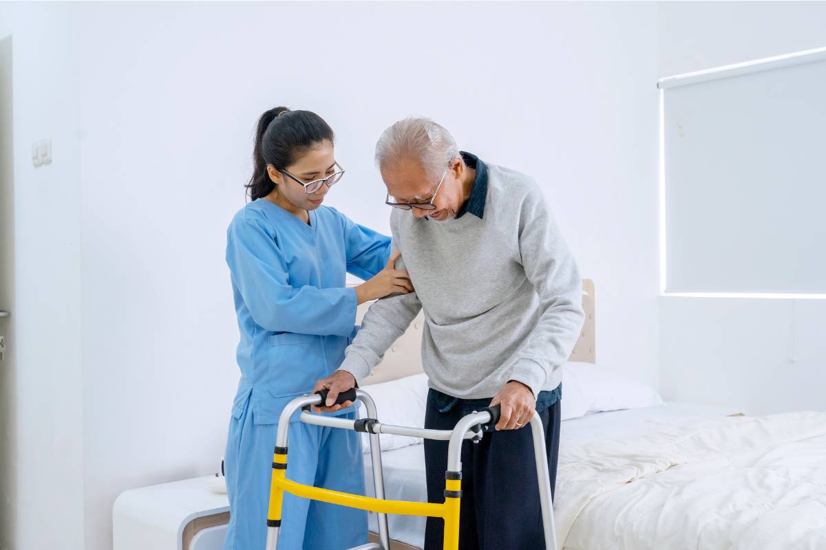 A nurse with ASLS certification assisting a patient with a walker.