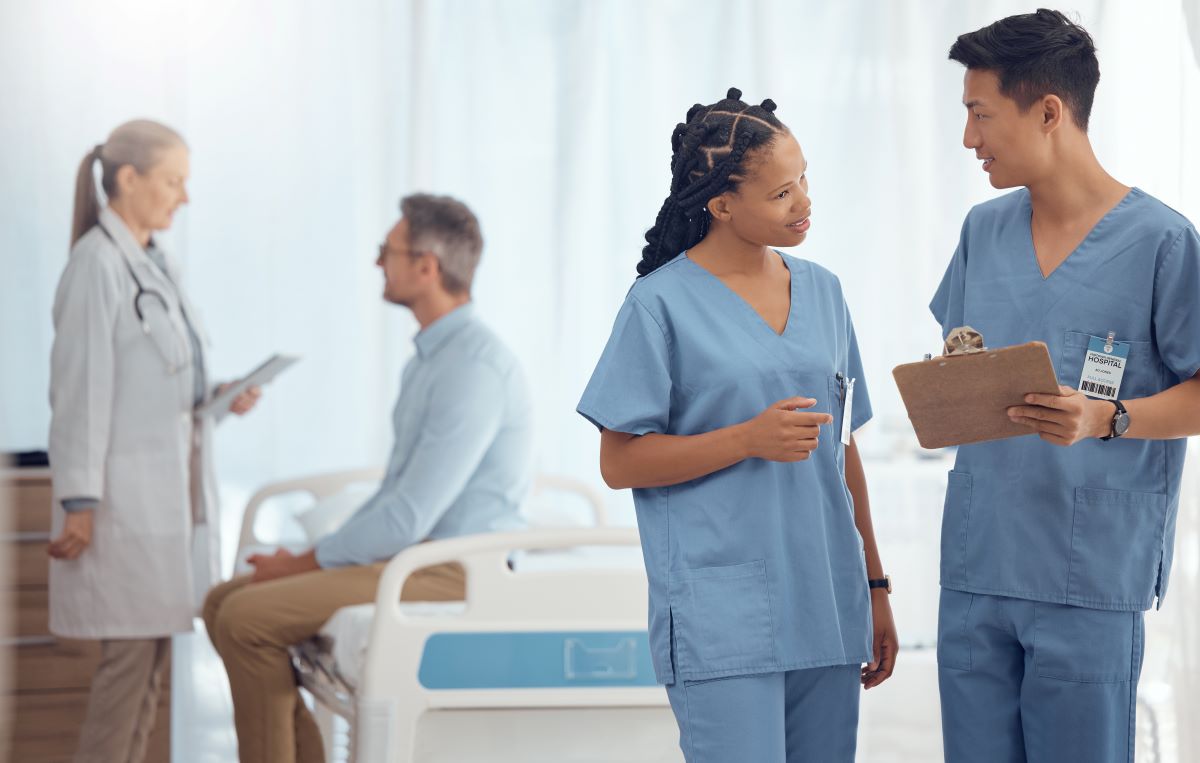 A charge nurse meets with one of his coworkers.
