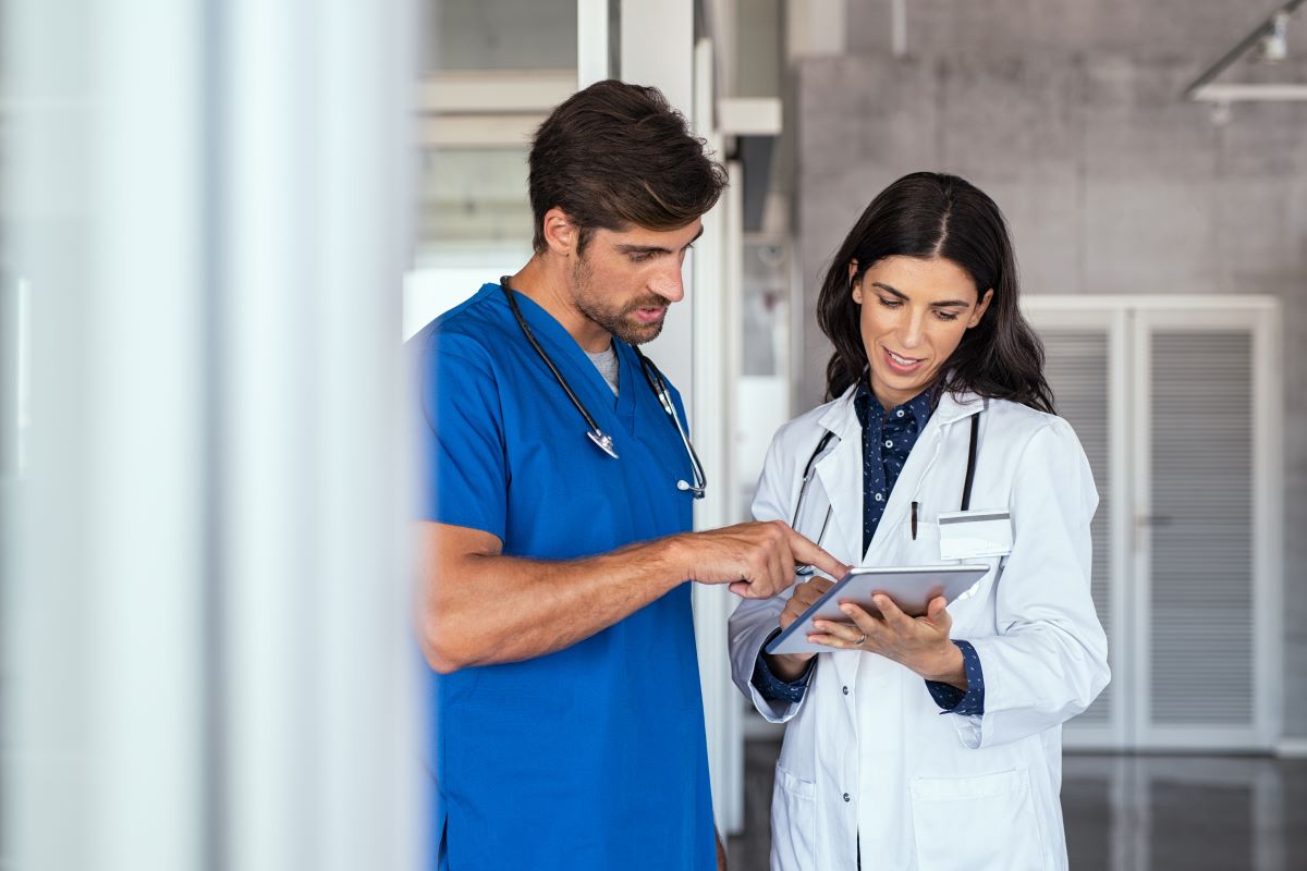 A circulating nurse meets with his supervising physician prior to a surgery.