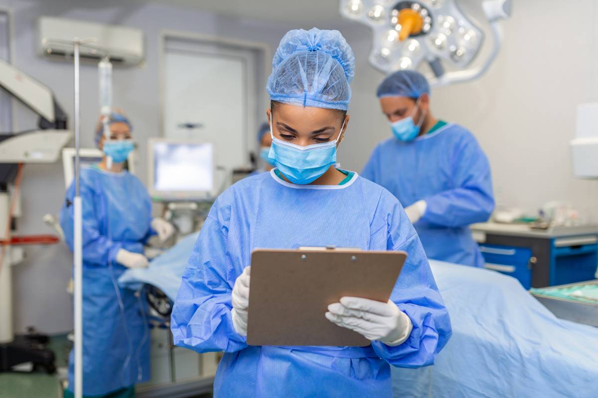 A circulating nurse takes notes before a surgical procedure.