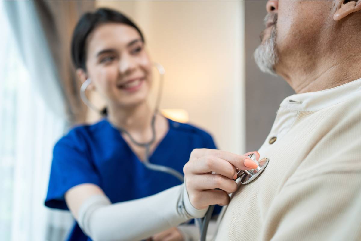 A nurse with CMC certification listens to a patient's heartbeat.