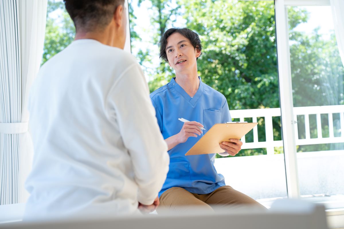 A certified nursing assistant (CNA) helps one of his patients.