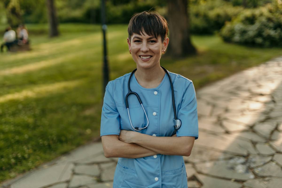 A nursing professional poses for a photo while discussing how to switch from cna to lpn.