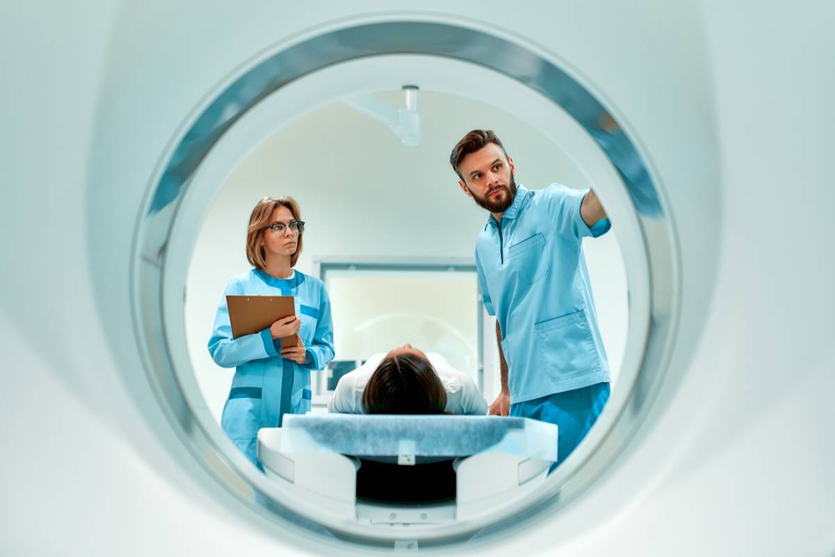 A med tech with CNMT certification prepares a patient for an MRI.