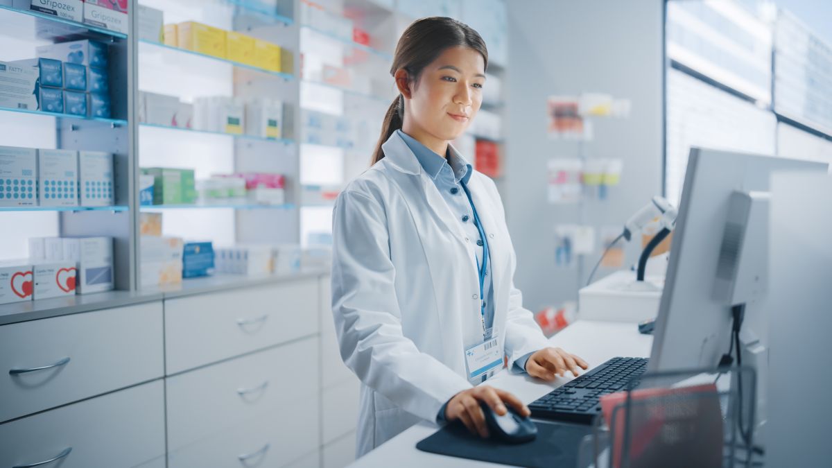 A hospital pharmacist checks the computer.