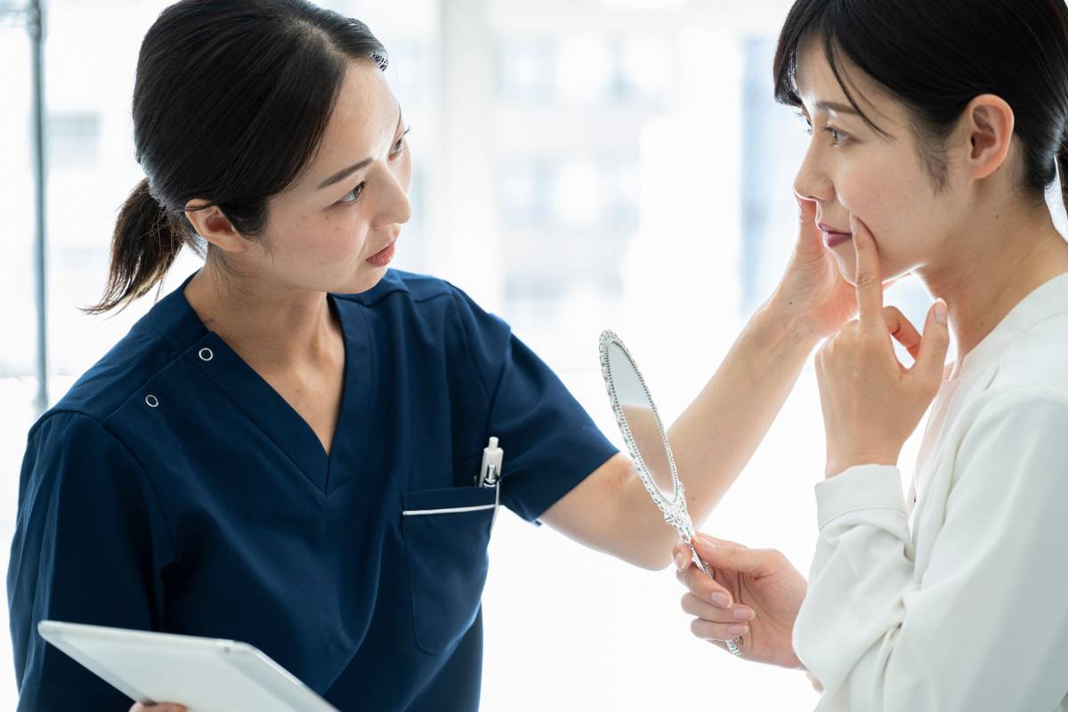 A dermatology nurse assesses a patient's skin.