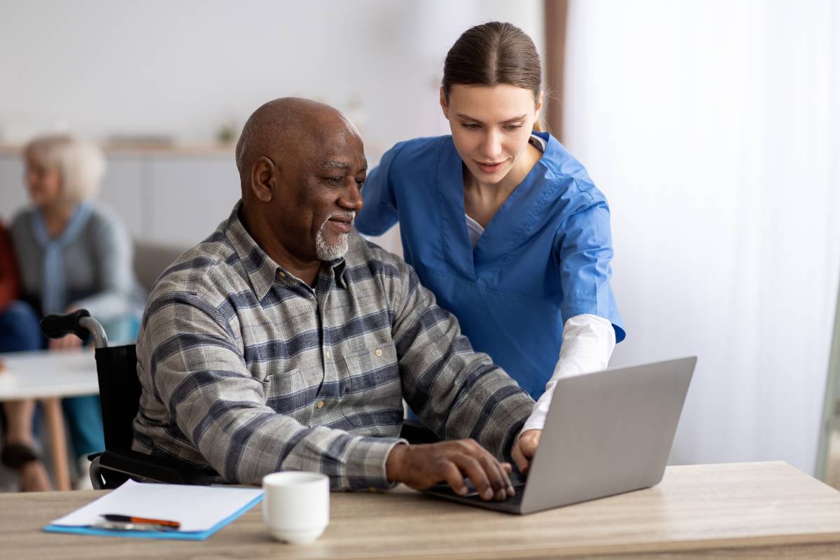 A diabetes nurse educator helps a patient fill out an online portal.