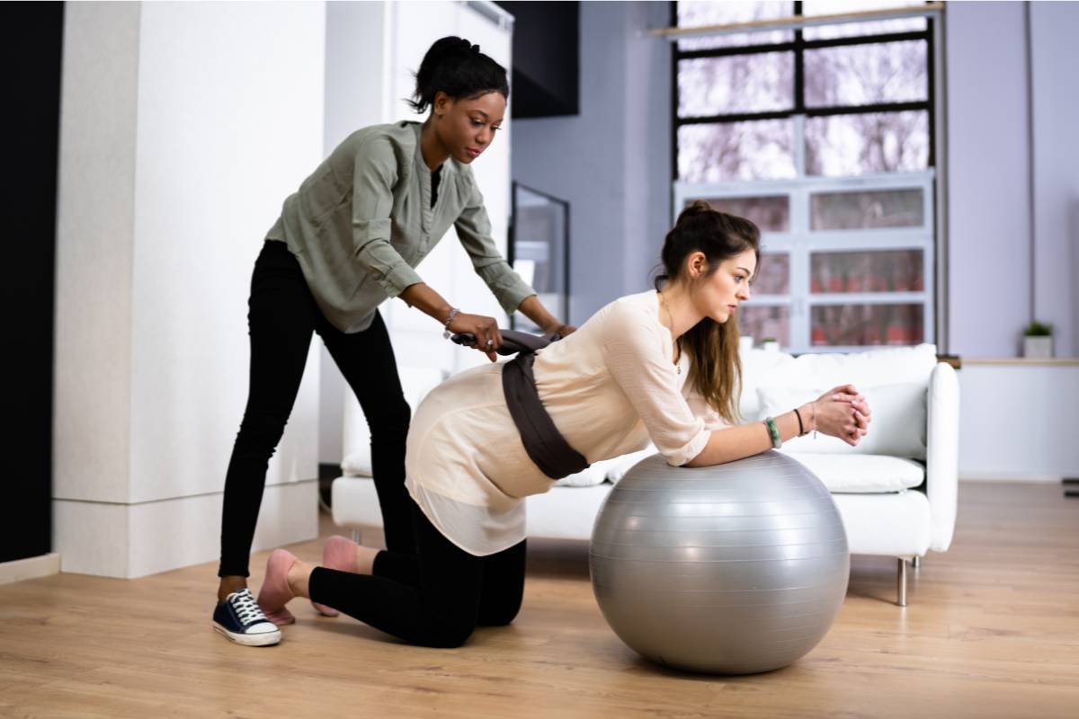 A doula practices skills included in her doula cover letter while assisting a patient with birth preparation.