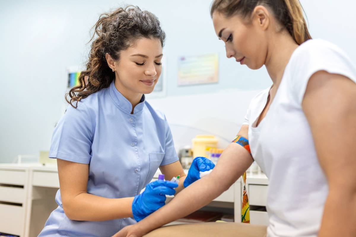 A forensic nurse practitioner draws blood from a patient.