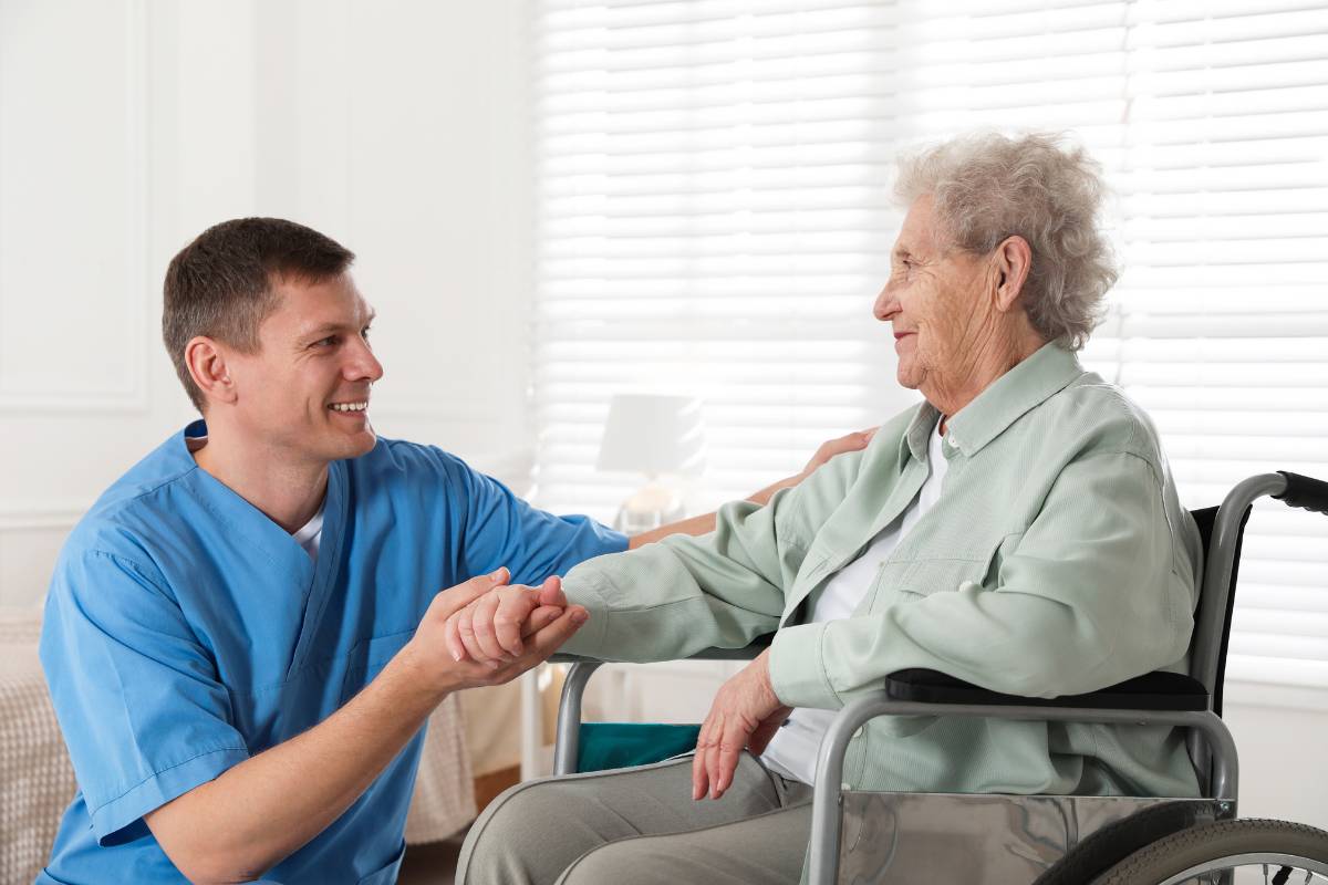 A geriatric nurse assists a patient.