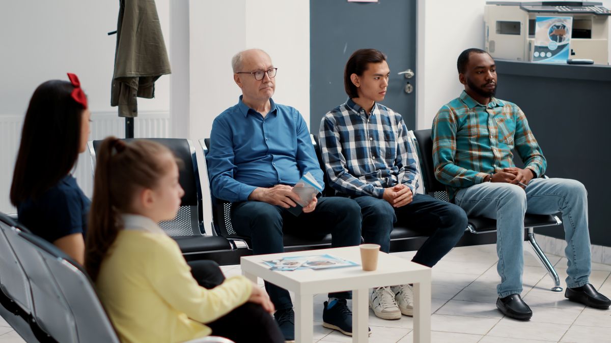 A diverse group of patients in the waiting room of a medical facility.