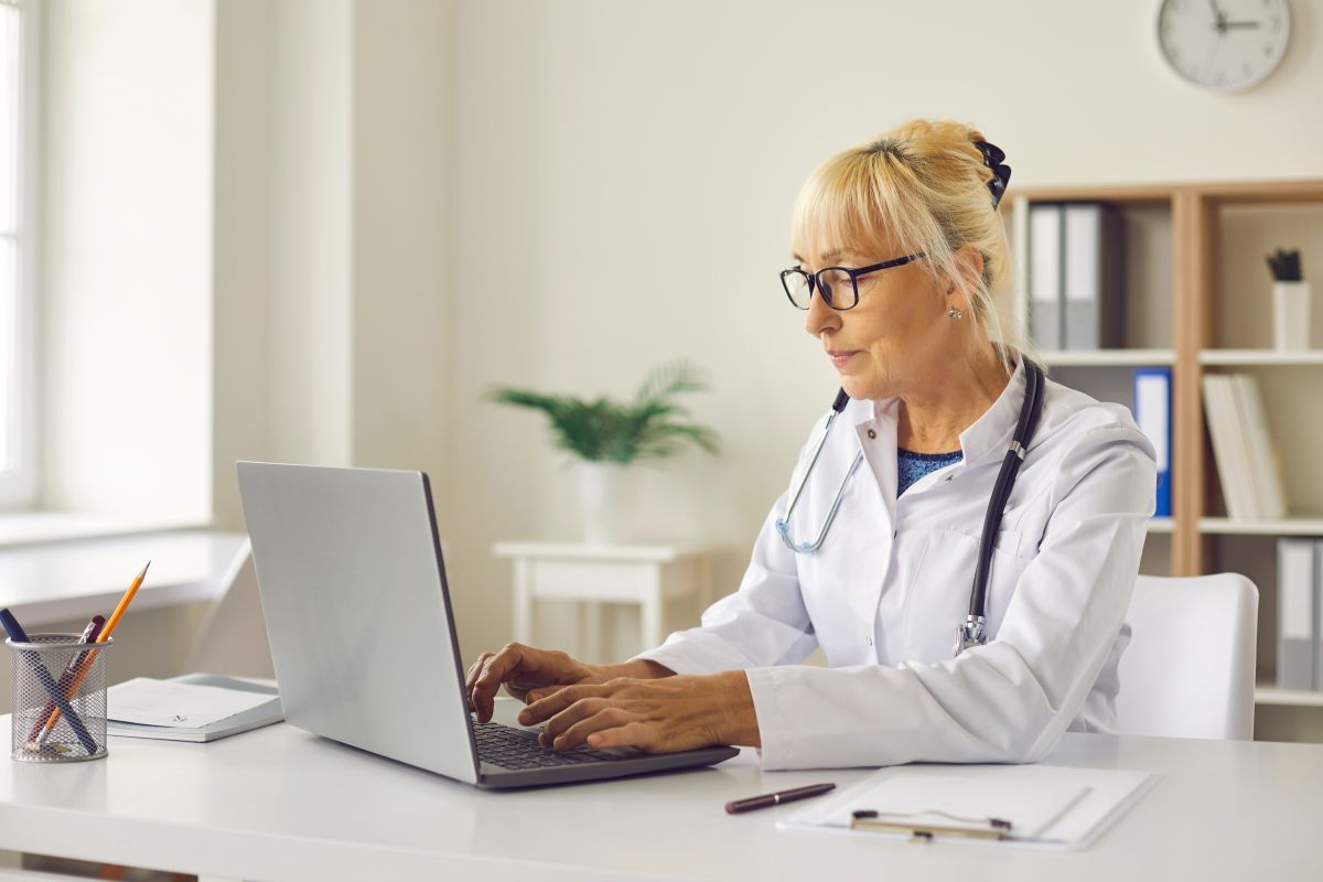 Female healthcare leader typing on a computer in an office