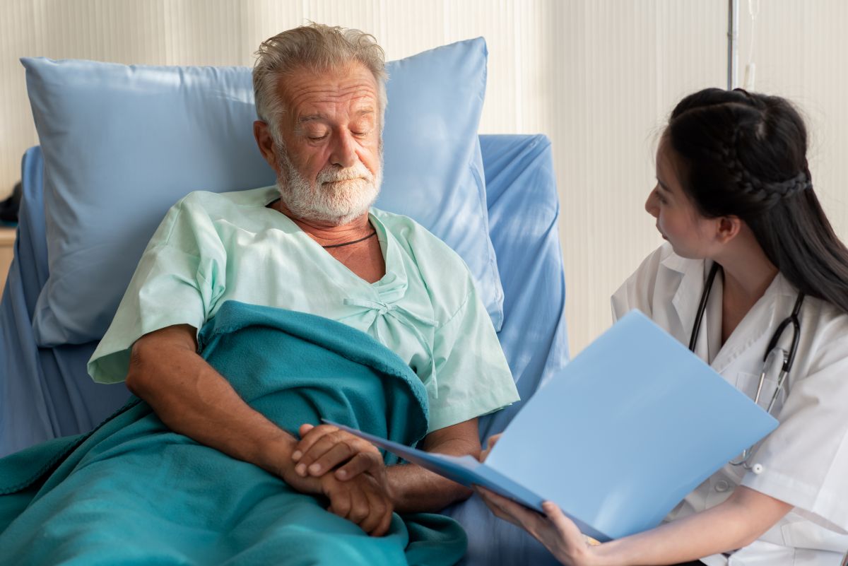 A nurse speaks with a hospital patient who doesn't speak English, using translation services.