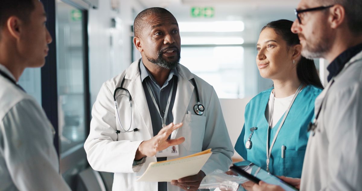 A member of hospital management meets with colleagues.