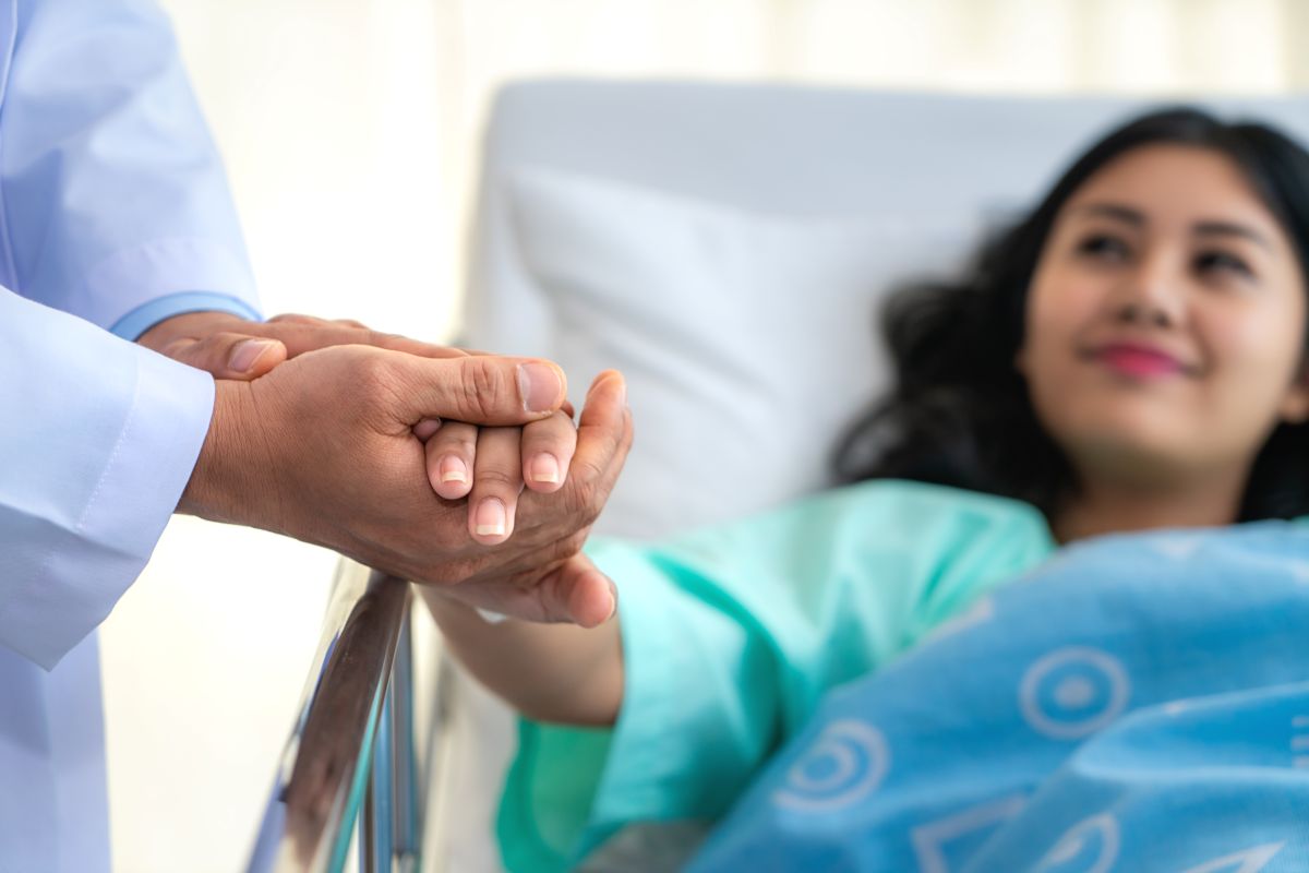 A patient taking part in a hospital swing bed program is comforted by her physician.