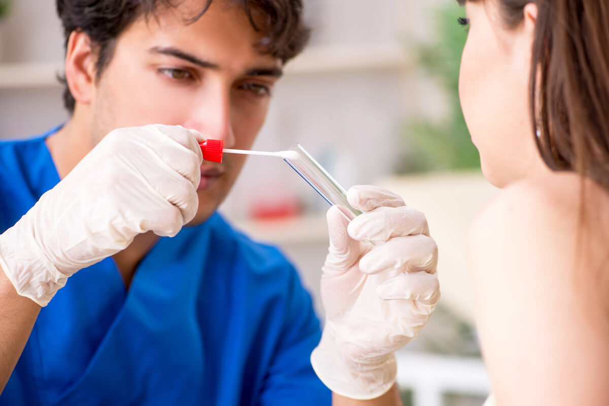 Forensic nurse taking a mouth swab from a patient.