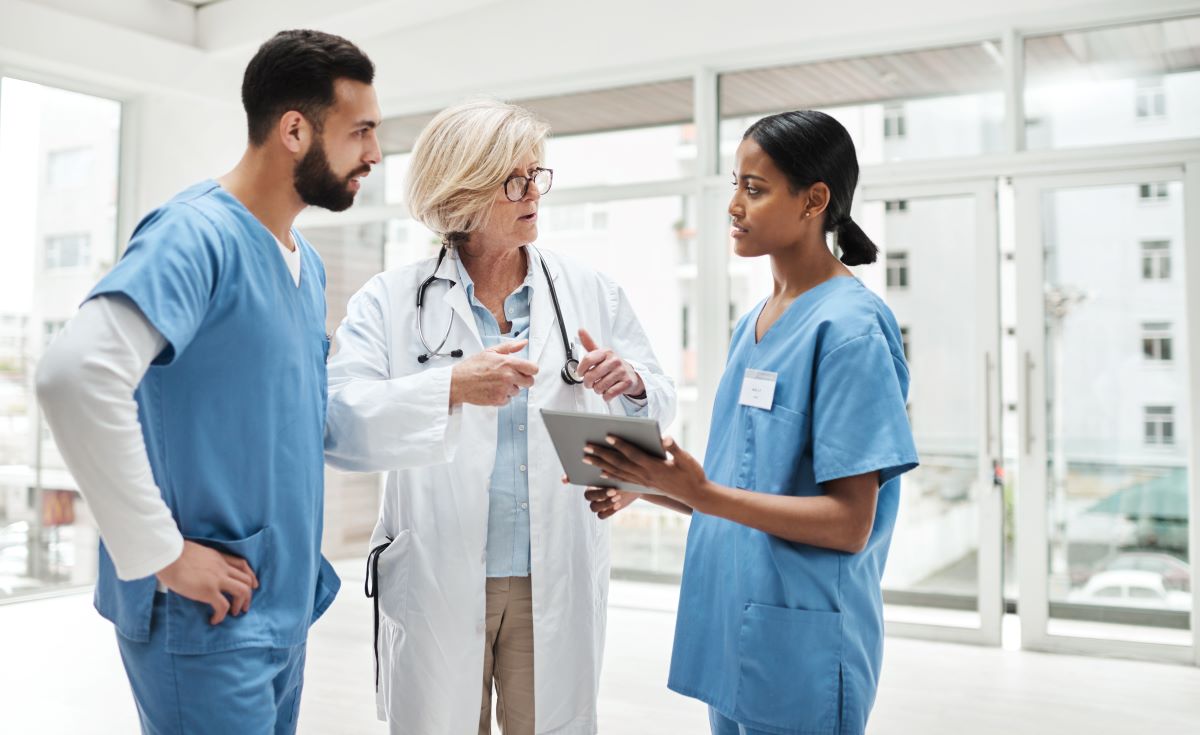 Two nurses and a physician discuss the treatment for a patient.
