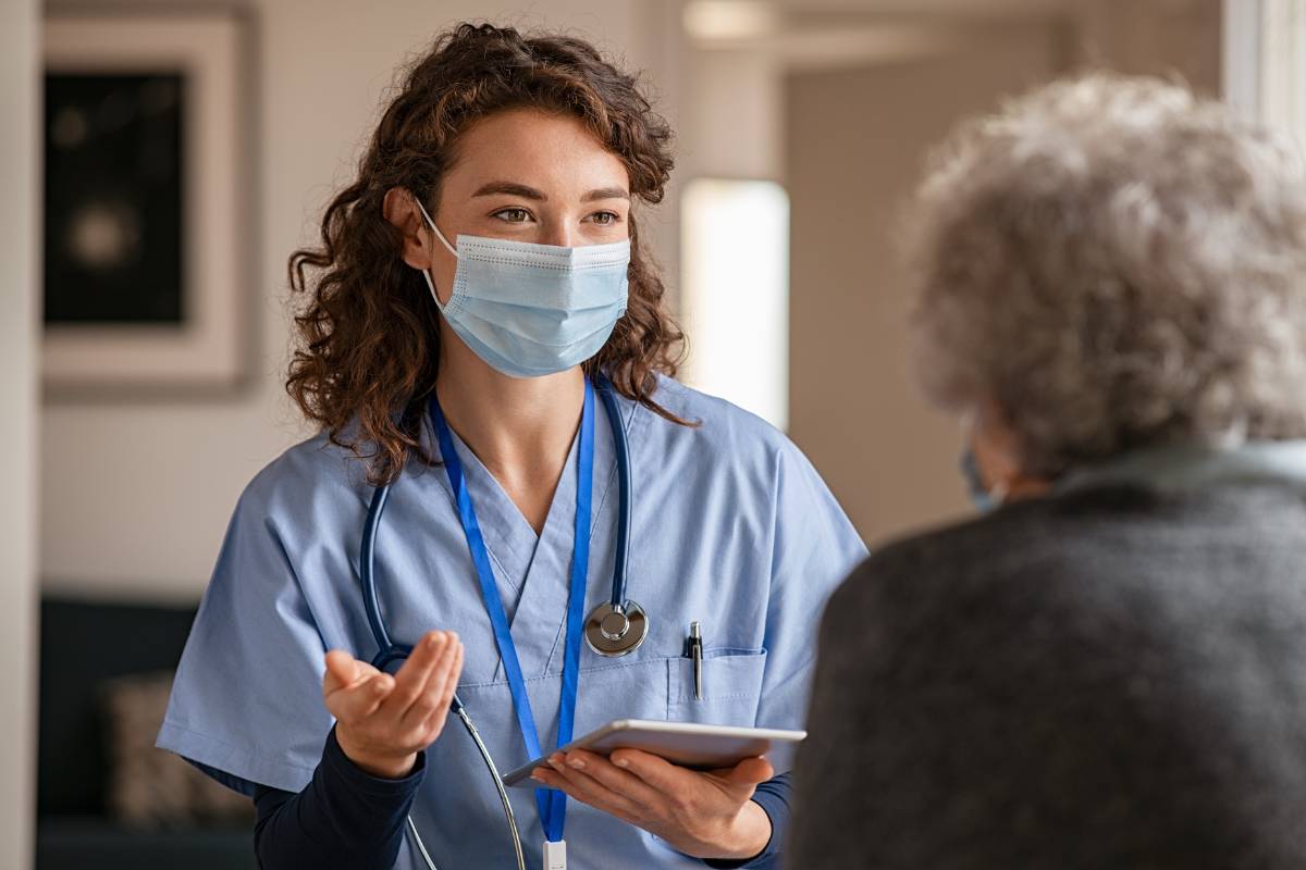 An infectious disease nurse practitioner consults with a patient.