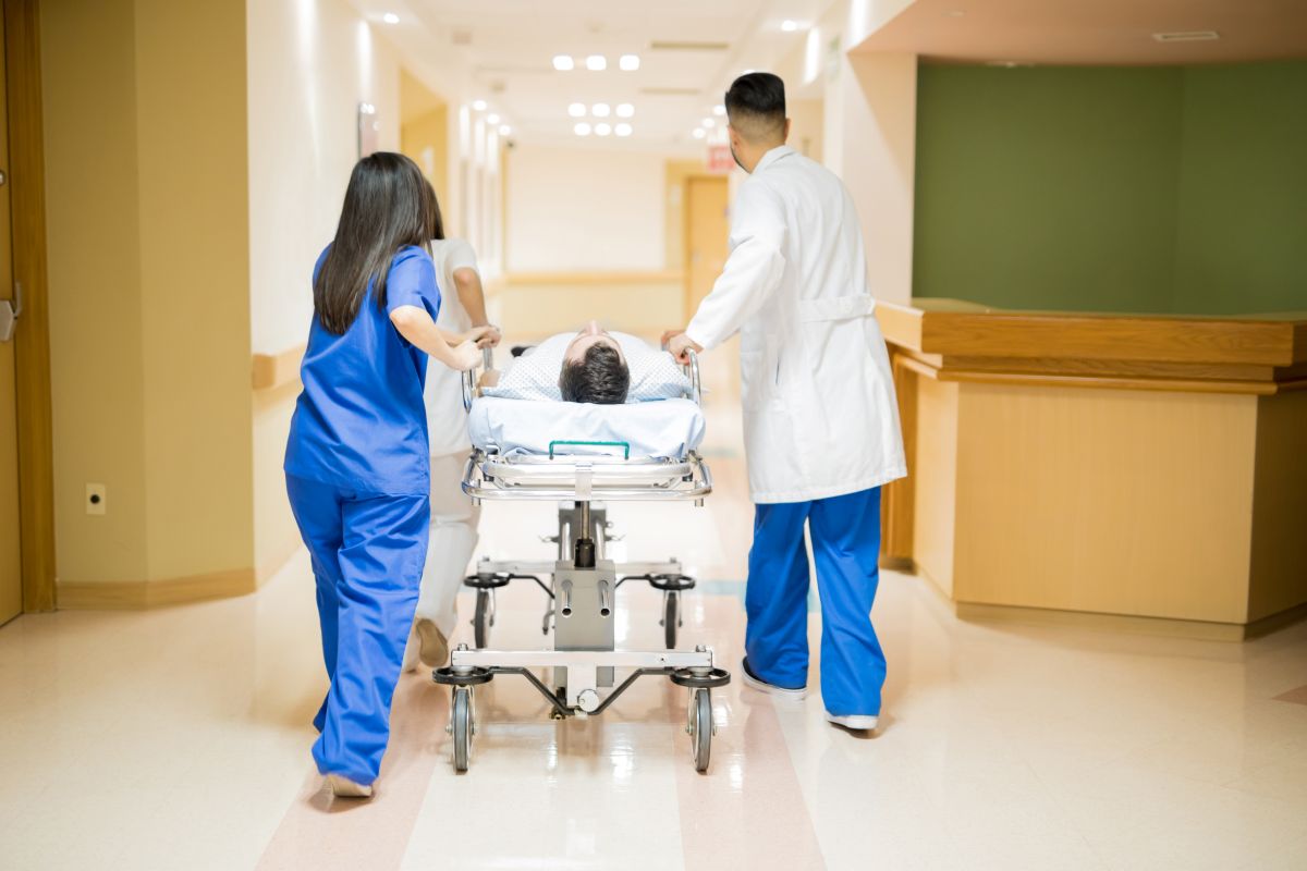 A doctor and nurse wheel a patient into the operating room.