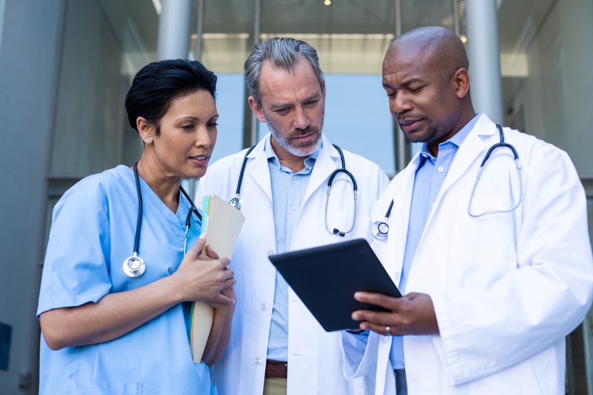 An Iowa nurse talks with two physicians, as they look at a patient's chart.