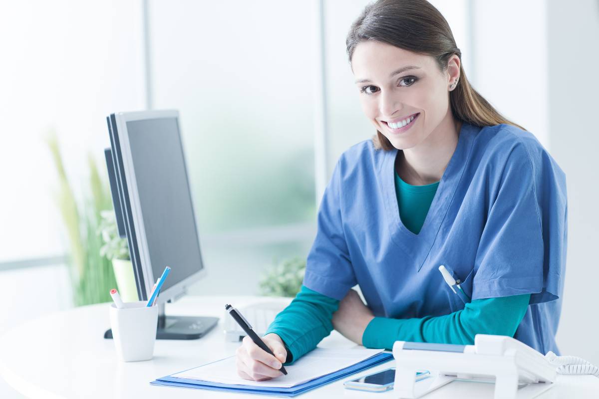 LVN in blue scrubs writes an LVN cover letter.