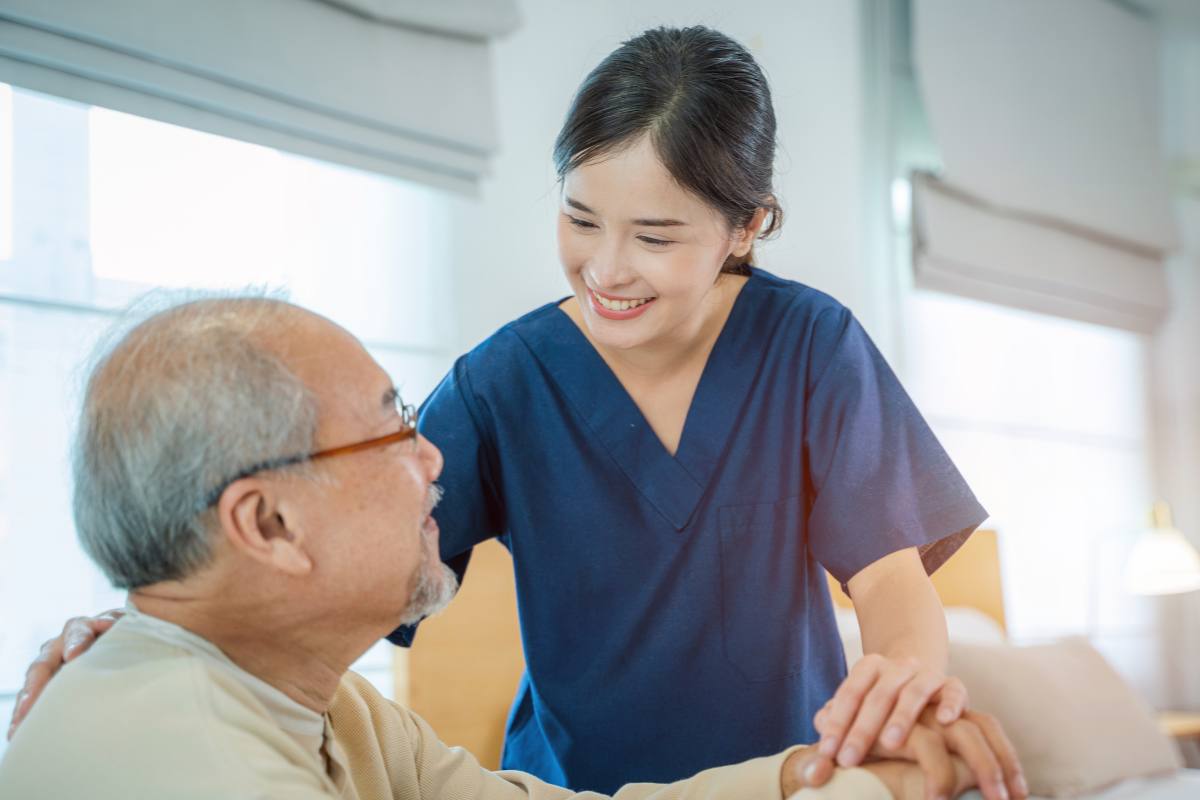 A nursing assistant speaks with a patient about the difference between LVN vs. CNA roles.