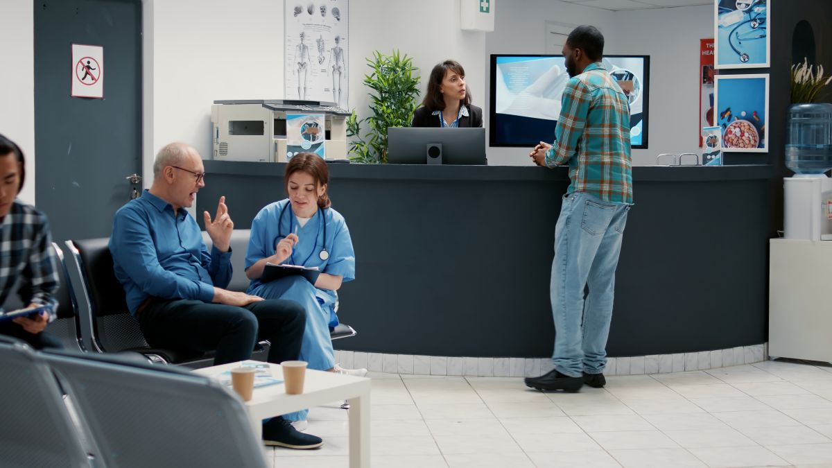 Wide shot showing the waiting room and reception desk of a medical clinic.
