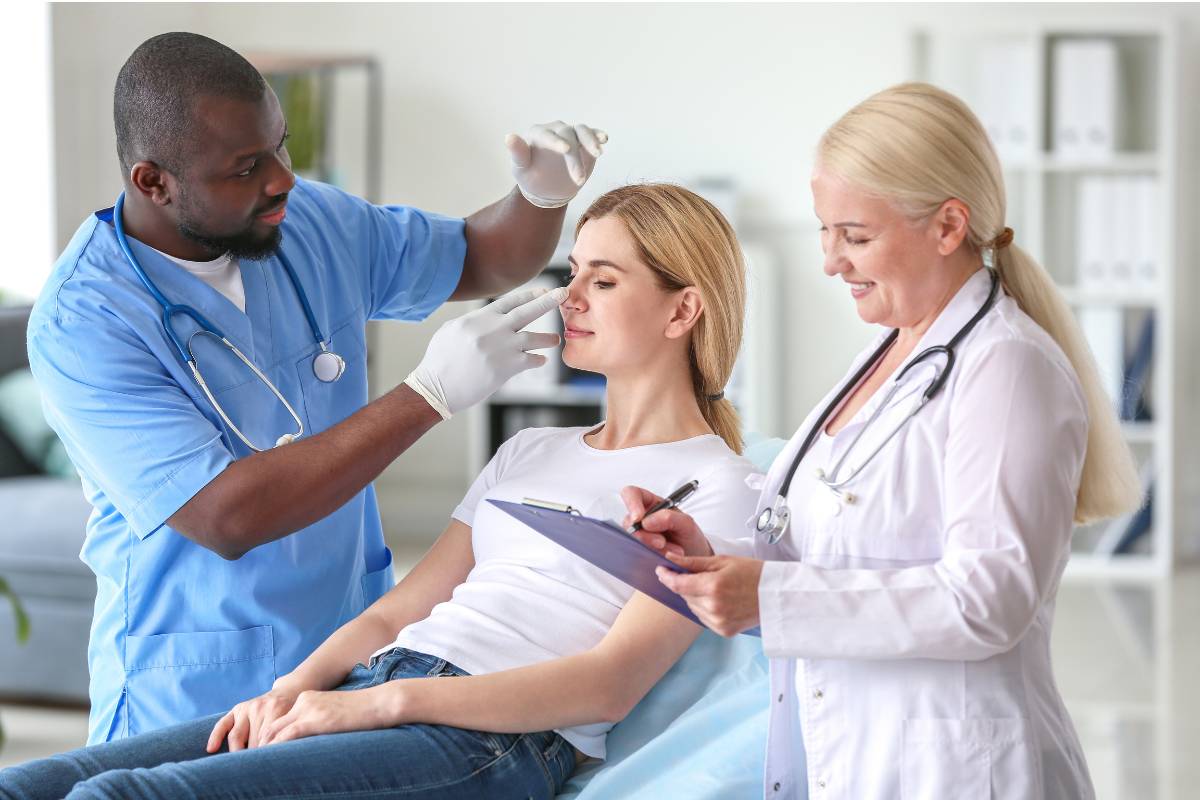 A med spa nurse assesses a patient's skin during an appointment.