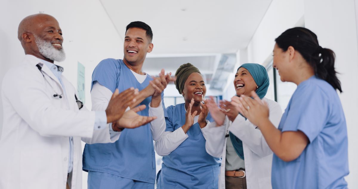 Group of medical staff laughing together in a hallway