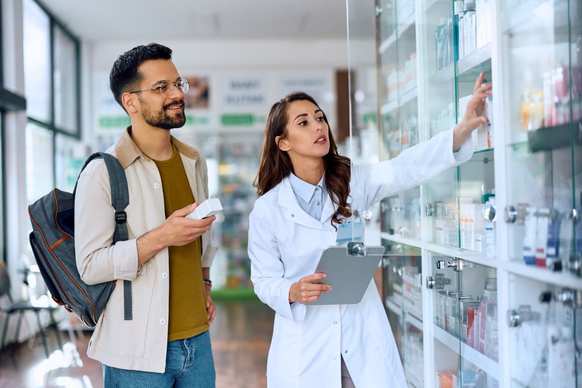A medication aide assists a patient with his meds.