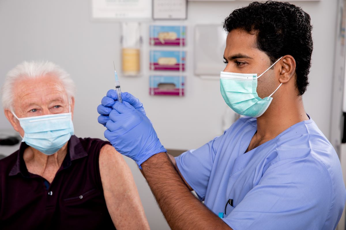 A nurse prepares a syringe for a patient awaiting medication.