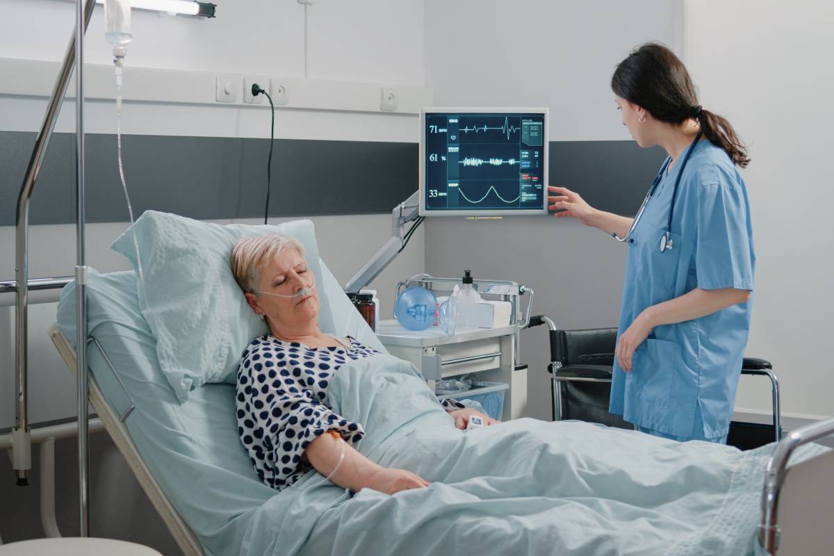 A nurse with MEDSURG-BC certification checks a patient's monitors.