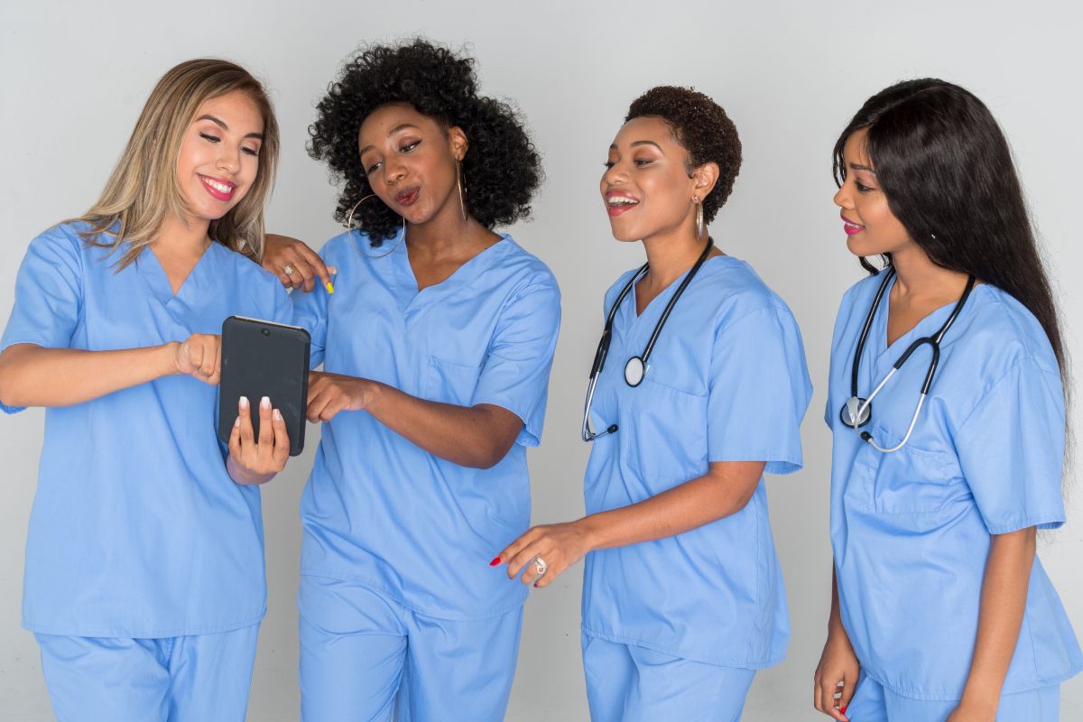 Four Mississippi nurses looking at a tablet computer together.