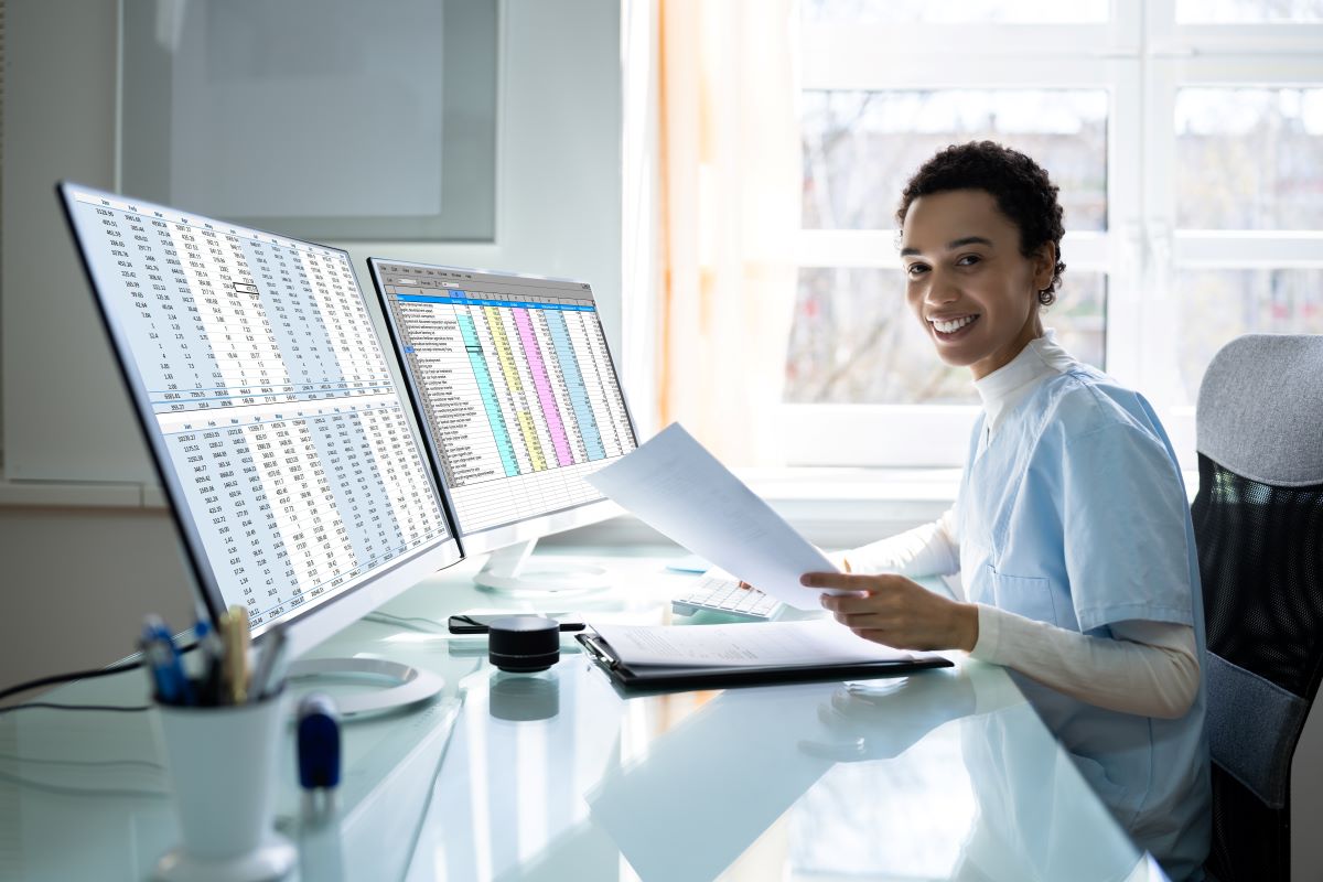 A medical biller at her desk, reviewing a patient's bill.
