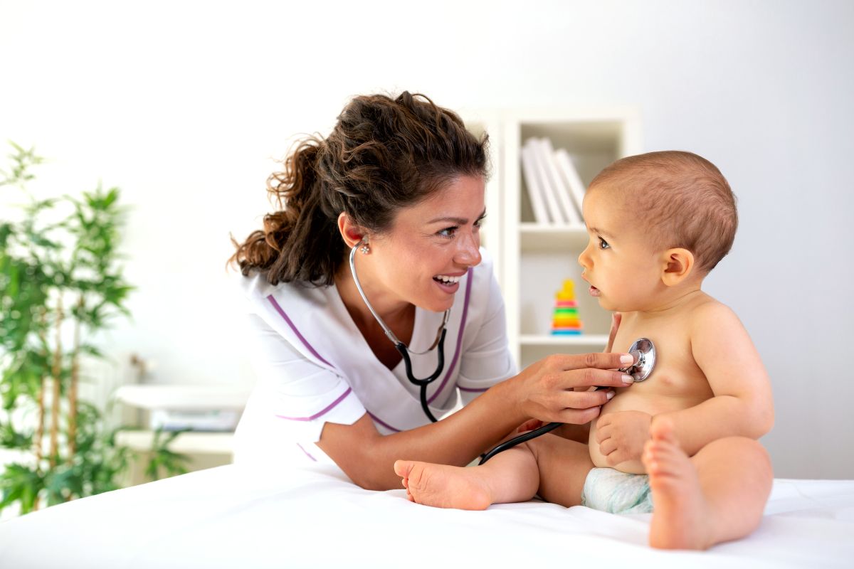 A neonatal nurse practitioner checks a baby's heartbeat.