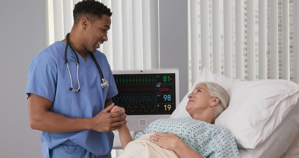 A nurse comforts one of his patients in a Nevada hospital bed.