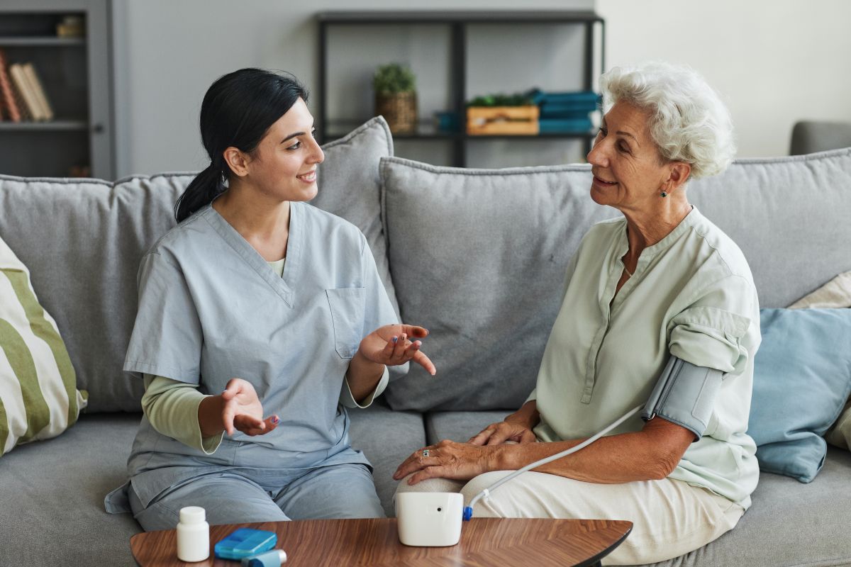 A nursing assistant meets with a patient at a long-term care center.