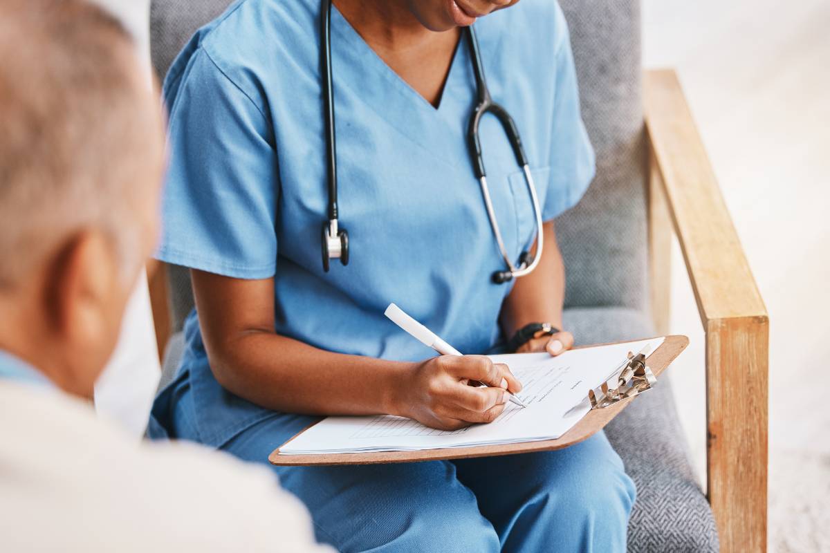 A nurse writes patient information on her nursing brain sheet.